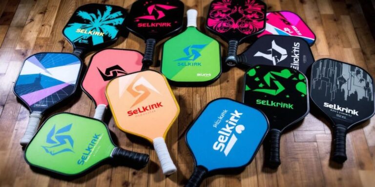 Colorful Selkirk pickleball paddles on a wooden surface.